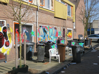 829578 Gezicht op volle kliko's op straat en van graffiti op de voorgevels van de leegstaande panden Aardbeistraat ...